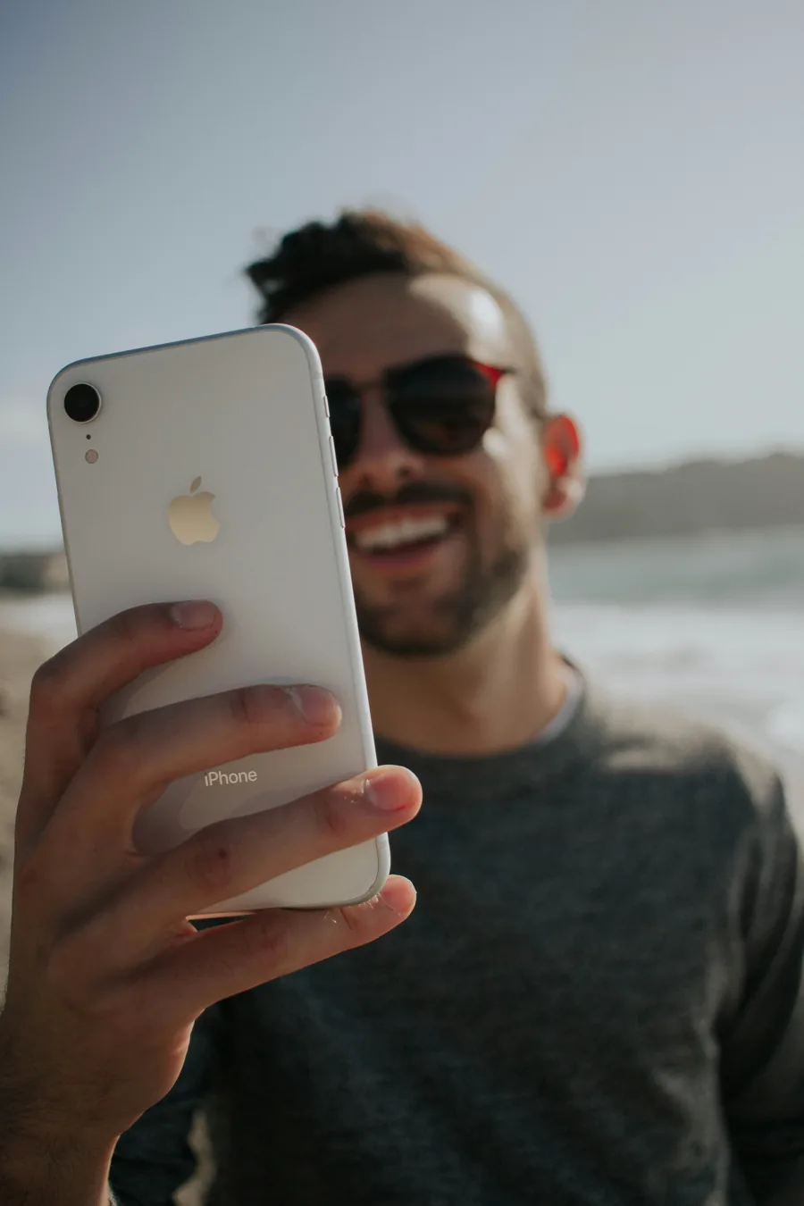 Homem sorrindo segurando o celular